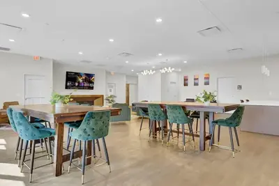 a dining room with wooden tables and green chairs at Rhythm & Blues 2 BD Repose Near Rock & Roll HOF in Cleveland