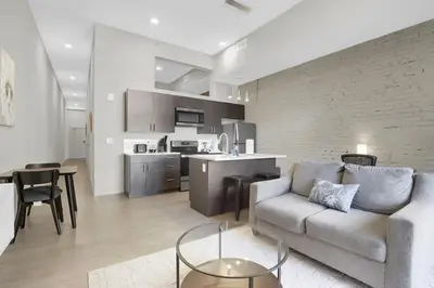 a living room with a couch and a kitchen at Soiree Vibes Bricks & Balcony 2Bx2B DT Cleveland in Cleveland
