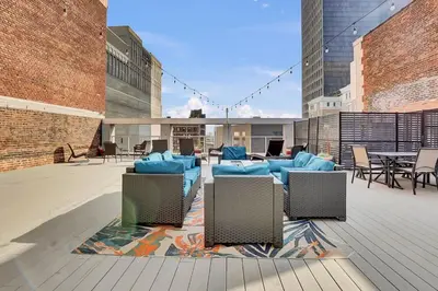 a patio with blue chairs and tables on a building at Billiards & Balcony 2Bx2B Rooftop It's Lit in Cleveland