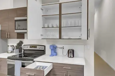 a kitchen with white cabinets and a blue appliance at Billiards & Balcony 2Bx2B Rooftop It's Lit in Cleveland