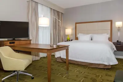 a hotel room with a bed and a desk and a television at Hampton Inn & Suites New Albany Columbus in New Albany
