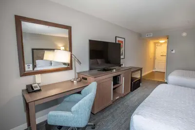a hotel room with a desk with a television and a bed at Hampton Inn & Suites - Cincinnati/Kenwood, OH in Cincinnati