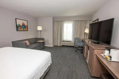 a hotel room with a bed and a flat screen tv at Hampton Inn & Suites - Cincinnati/Kenwood, OH in Cincinnati