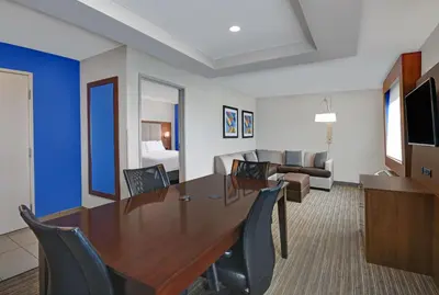 a room with a table and chairs and a couch at Holiday Inn Express Adrian by IHG in Adrian