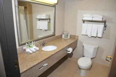 a bathroom with a sink and a toilet and a mirror at Wingate by Wyndham Ashland in Ashland
