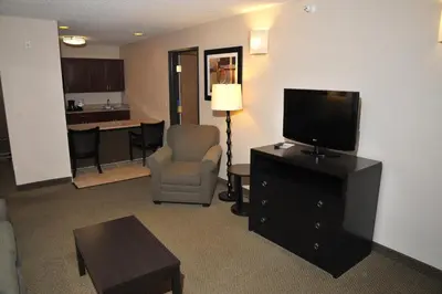 a living room with a television and a chair at Wingate by Wyndham Ashland in Ashland