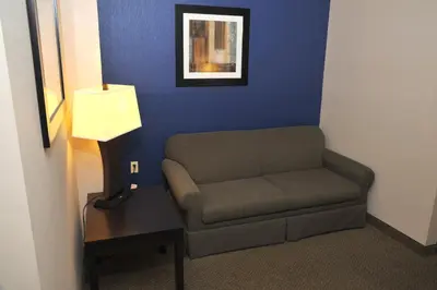 a room with a couch and a table and a lamp at Wingate by Wyndham Ashland in Ashland