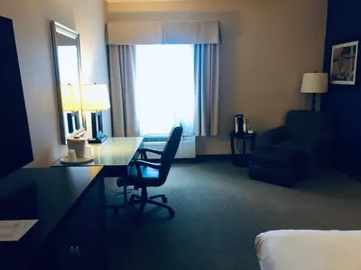 a hotel room with a desk and a chair at Wingate by Wyndham Ashland in Ashland