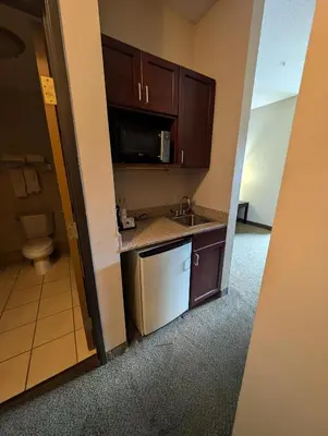 a small kitchen with a sink and a microwave at Wingate by Wyndham Ashland in Ashland