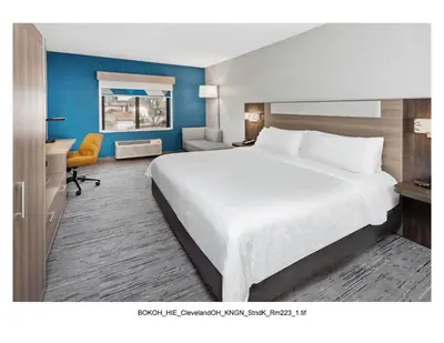 a hotel room with a large bed and a desk at Holiday Inn Express Cleveland Airport - Brook Park by IHG in Brook Park