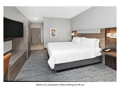 a hotel room with a bed and a flat screen tv at Holiday Inn Express Cleveland Airport - Brook Park by IHG in Brook Park