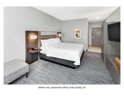 a hotel room with a bed and a flat screen tv at Holiday Inn Express Cleveland Airport - Brook Park by IHG in Brook Park