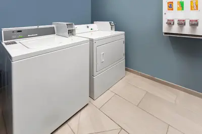 a laundry room with a washer and dryer at Holiday Inn Express Cleveland Airport - Brook Park by IHG in Brook Park