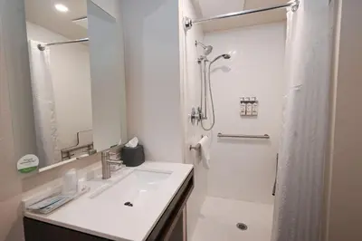 a white bathroom with a sink and a shower at Holiday Inn Cleveland-Mayfield by IHG in Mayfield