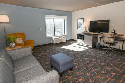a living room with a couch and a flat screen tv at Holiday Inn Cleveland-Mayfield by IHG in Mayfield