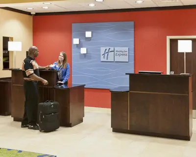 a man and a woman standing at a reception desk at Holiday Inn Express & Suites Dayton South - I-675 by IHG in Shanersville
