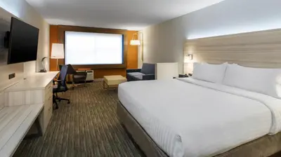 a hotel room with a large bed and a television at Holiday Inn Express & Suites Medina by IHG in Medina