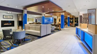 a lobby of a hotel with chairs and tables at Holiday Inn Express & Suites Medina by IHG in Medina