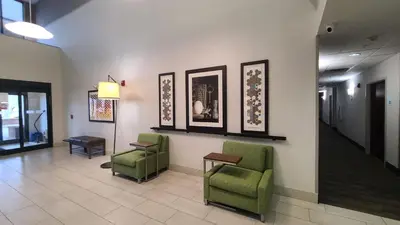 a waiting room with chairs and pictures on the wall at Holiday Inn Express Lordstown-Newton Falls/Warren by IHG in Newton Falls