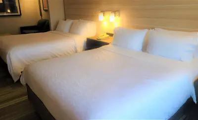 two beds in a hotel room with white sheets at Holiday Inn Express Lordstown-Newton Falls/Warren by IHG in Newton Falls