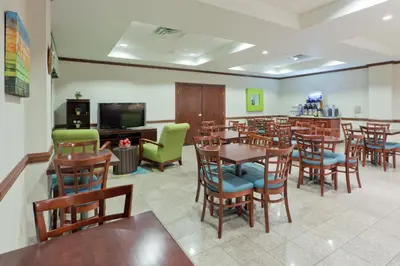 a dining room with tables and chairs and a tv at Holiday Inn Express Lordstown-Newton Falls/Warren by IHG in Newton Falls