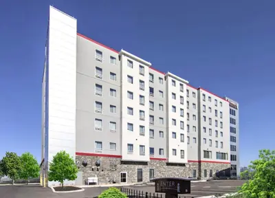 a large white building with a red roof at Staybridge Suites - University Area OSU by IHG in Columbus
