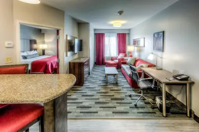 a hotel room with a couch and a bed at Staybridge Suites - University Area OSU by IHG in Columbus