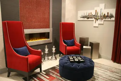 two red chairs in a living room with a fireplace at Staybridge Suites - University Area OSU by IHG in Columbus