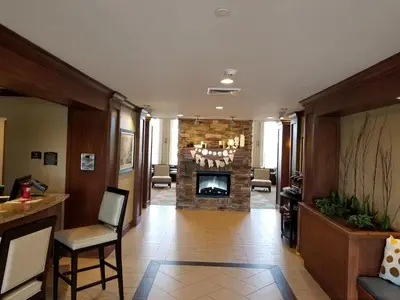 a living room with a fireplace in the middle at Staybridge Suites Toledo - Rossford - Perrysburg by IHG in Rossford