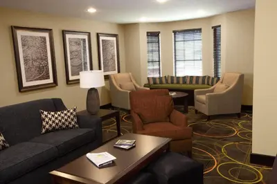 a living room with couches and chairs at Staybridge Suites Toledo - Rossford - Perrysburg by IHG in Rossford