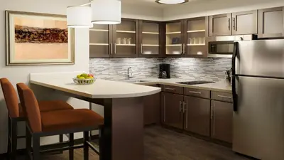 a kitchen with a kitchen island with a refrigerator at Staybridge Suites Toledo - Rossford - Perrysburg by IHG in Rossford