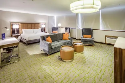 a hotel room with a bed and a couch and chair at DoubleTree by Hilton Huntington, WV in Huntington