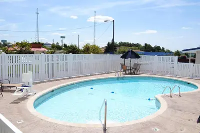 a large swimming pool with a white fence at Americas Best Value Inn & Suites St Clairsville Wheeling in Saint Clairsville