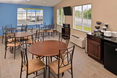 a dining room with tables and chairs and a kitchen at Americas Best Value Inn & Suites St Clairsville Wheeling in Saint Clairsville