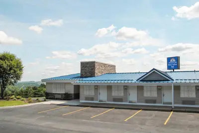 a building with a blue roof and a parking lot at Americas Best Value Inn & Suites St Clairsville Wheeling in Saint Clairsville