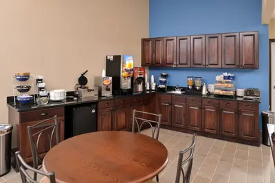 a kitchen with a wooden table and a counter top at Americas Best Value Inn & Suites St Clairsville Wheeling in Saint Clairsville