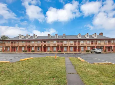a large building with a parking lot in front of it at Red Roof Inn Uhrichsville in Uhrichsville