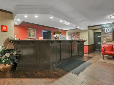 a bar in a lobby with a red wall at Red Roof Inn Uhrichsville in Uhrichsville
