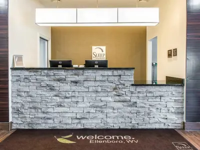 a lobby with a stone wall and two laptops on a counter at Sleep Inn Ellenboro Hwy 50 in Ellenboro