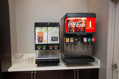 two cocacola machines sitting on a counter with drinks at Staybridge Suites Miamisburg by IHG in Miamisburg