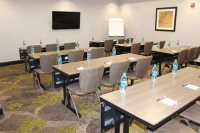 a room with tables and chairs with water bottles on them at Staybridge Suites Miamisburg by IHG in Miamisburg