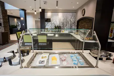 a glass display case with food on a table at Staybridge Suites Miamisburg by IHG in Miamisburg