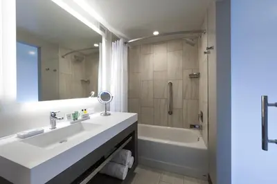 a bathroom with a sink and a tub and a mirror at Hilton Cleveland Downtown in Cleveland