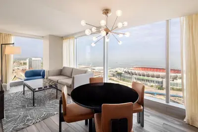 a living room with a table and a large window at Hilton Cleveland Downtown in Cleveland