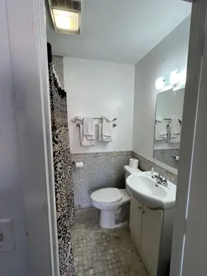 a bathroom with a white toilet and a sink at Liberty Motel in Liberty