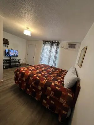 a hotel room with a bed and a tv at Liberty Motel in Liberty