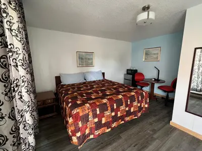 a hotel room with a bed and a table at Liberty Motel in Liberty