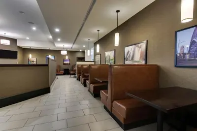 a restaurant with a waiting room with chairs and tables at Drury Plaza Hotel Cleveland Downtown in Cleveland