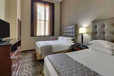 a hotel room with two beds and a flat screen tv at Drury Plaza Hotel Cleveland Downtown in Cleveland