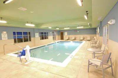 a large pool in a hospital with chairs and a table at Holiday Inn Express & Suites Toledo West by IHG in Toledo